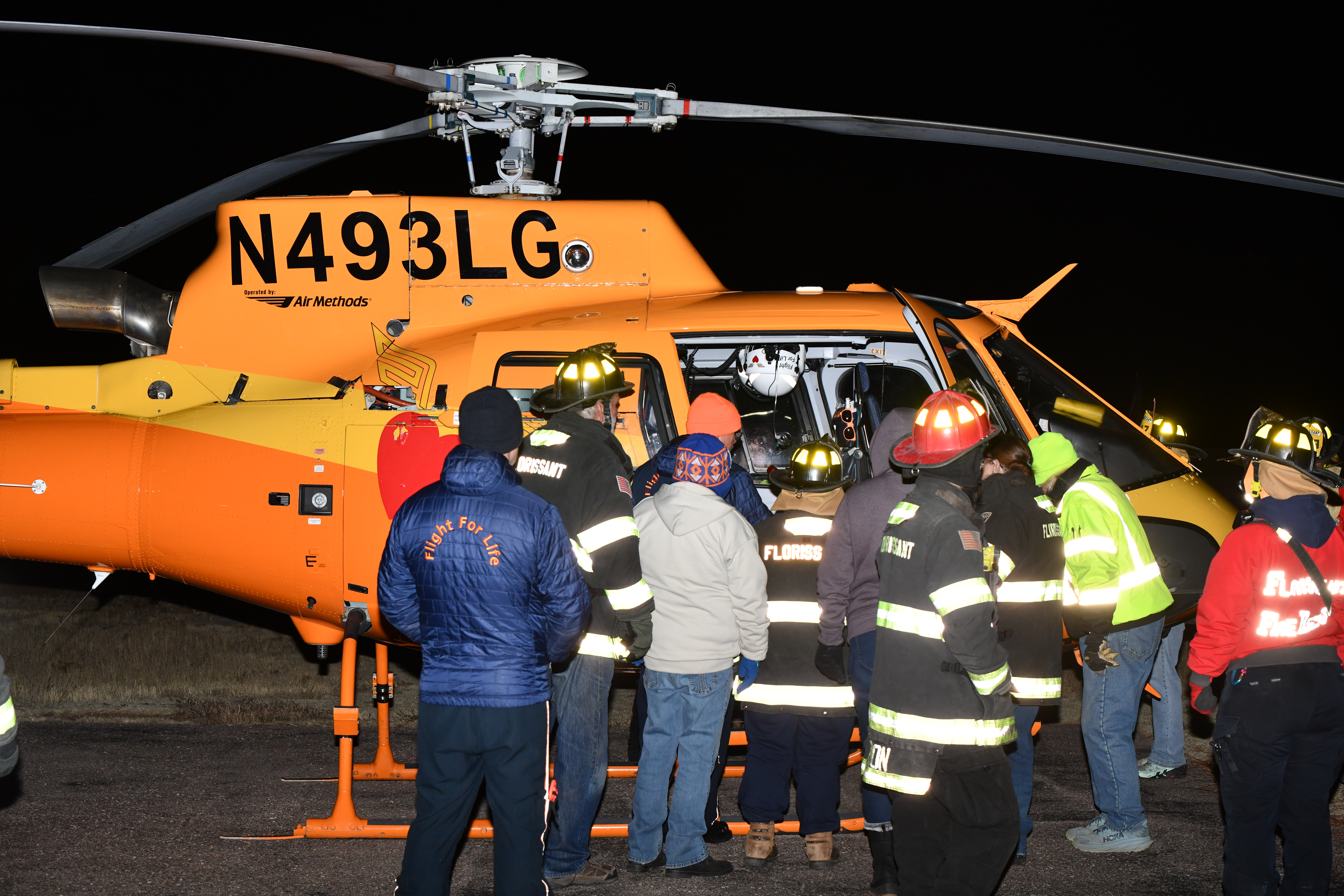 Firefighters gathered around a Flight for Life helicopter